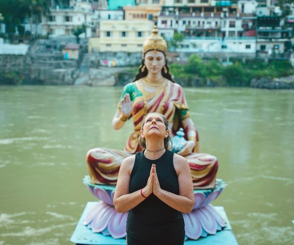 Person meditating peacefully with a serene background.